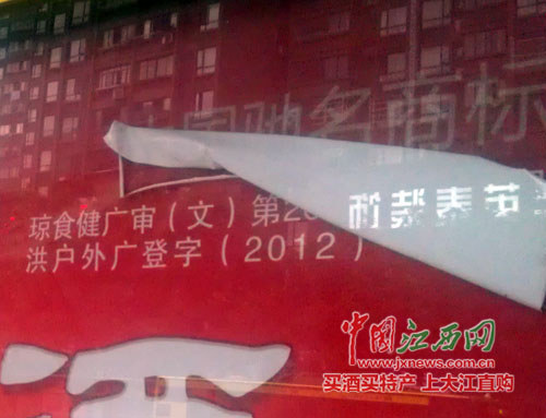 椰岛集团酒广告牌上红布脱落，露出“中国驰名商标”字样。